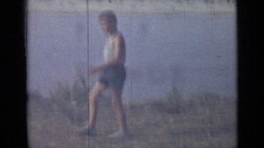 1962: Boy in Shorts and Shirt Walking Along Water Enjoying Cookout, Russia