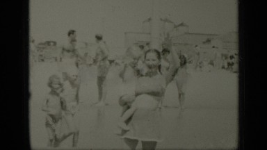 1949: Mom Holds Baby as They Walk Into Ocean Waves New York