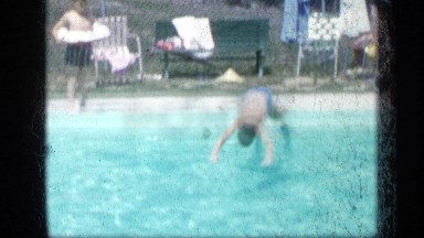 1957: happy boy dives into pool, smiles and waves NEW YORK