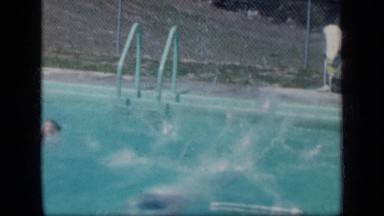 1957: man dives into outdoor pool and does laps near boy who is swimming