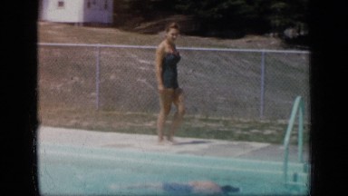 1957: beautiful women in swimsuit dives into pool and swim to other side