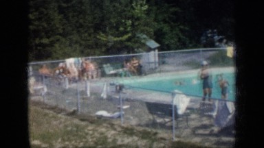 1957: dozens of people swimming and sunning around public swimming pool NEW YORK