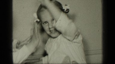 1957: Two Smiling Girls in Pajamas Playing Pattycake and Blowing Kisses