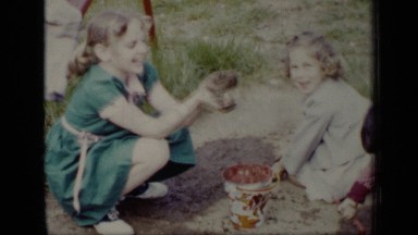 1948: small children play in mud then smile to videographer NEW YORK