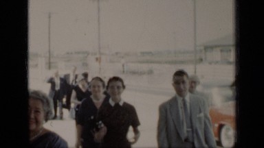 1948: people dressed formal gathering into building for special occasion