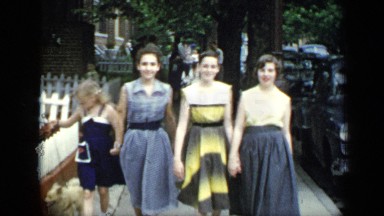 1948: four girls are walking together with their dogs at time of evening