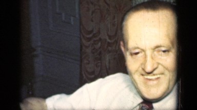 1949: man wearing dress shirt and tie talks and smiles while seated NEW YORK