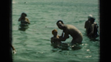 1949: father playing with his kid in river with some people around NEW YORK