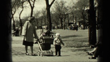 1949: women pushing carriage with baby on city street