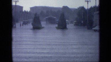 1971: Lone Car Drives Through Rain and Light Flooding in Moscow Town Square