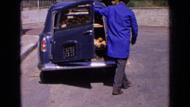 1963: person closing his car diggy where diggy has some objects