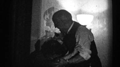 1947: An Elderly Man Playfully Wrestles with a Seated Elderly Woman