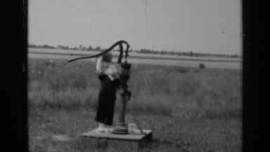 1947: a young boy tries to pull the handle on a water well ILLINOIS