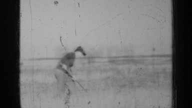 1947: a farmer tends to his crops in black and white footage showing him