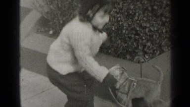 1947: a beautiful young lady walking on the sidewalk with her little puppy