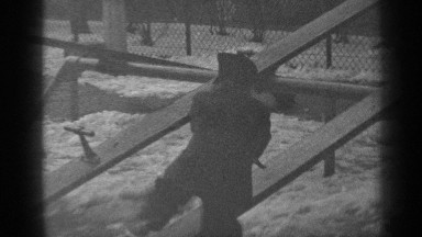 1947: black and white footage of a child in winter gear playing on a seesaw.