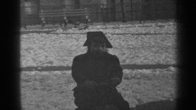 1947: a small child, outdoors on a playground, being lifted up and down