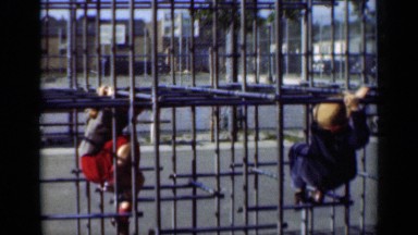 1947: party of children outside playing on a piece of metal equipment NEW YORK