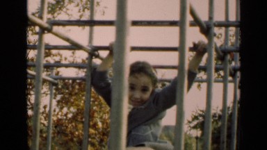 1947: adorable little girl climbs the monkey bars in a city park. NEW YORK