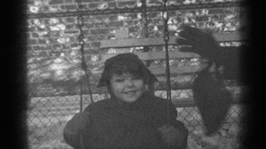 1947: black and white footage of mother pushing daughter on a swing. NEW YORK