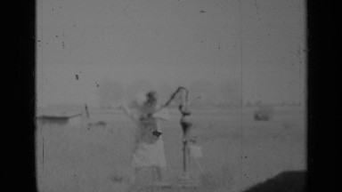 1948: a lady pumping the bore-well water in a sunny day INDIANA
