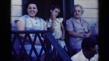 1948: family gathering on the porch as man catches a tossed item. INDIANA