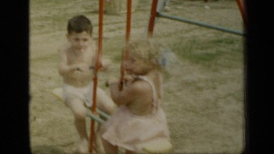 1948: two kids are playing in swings at the park morning time