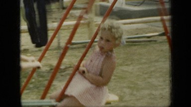 1948: children play on swings in back garden. NEW YORK