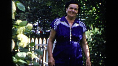 1948: Older Woman in Blue Dress Walks Through Garden in New York