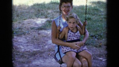 1948: woman with glasses holding a little girl playing on a swing NEW YORK