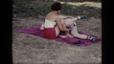 1948: couple relaxes in the shade on a towel NEW YORK
