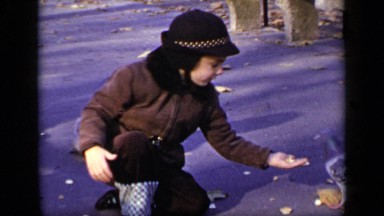 1948: a beautiful cute little girl is providing food for birds NEW YORK