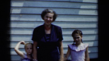1950: the mother and her daughters standing near to her home NEW YORK