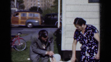 1950: a man and woman are walking with their little cute baby at outside