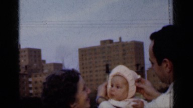 1950: a couple with a little baby wrapped in sweater chatting and moving