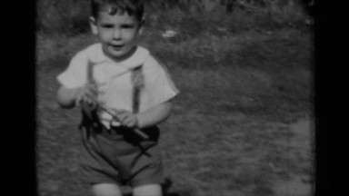 1950: two young children are socializing outside together in a grassy area