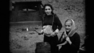 1950: Group of Young Girls Wearing Headscarves Roasting Marshmallows on Sticks