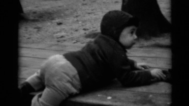 1950: a small kid trying to down from a bench located at the park NEW YORK