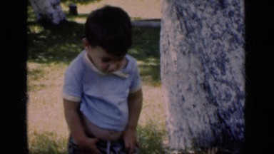 1951: a little cute boy trying to close his pant zip while he cannot NEW YORK