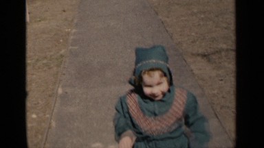 1951: a little girl shows off her baby doll in her baby carriage