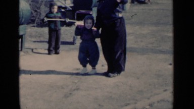 1951: father and children play outside on a cold day and wave to the camera