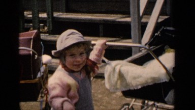 1951: two cute little girls outdoors near wooden steps, playing and pushing baby