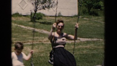 1951: the mother and her son moving back and forth on swing NEW YORK