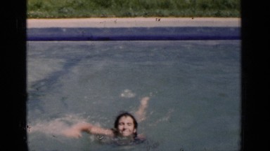 1951: a girl in a yellow bathing suit swimming through the water NEW YORK