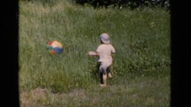 1951: a young boy wades into high grass to get his beach ball NEW YORK