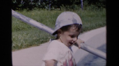 1951: boy wearing hat at pool rubs water on his face. NEW YORK