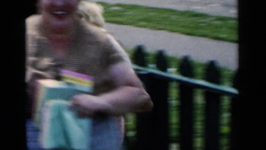 1951: adults in a front yard of a house smiling and running around. NEW YORK
