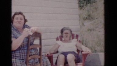 1951: family converses on the porch in the shade. NEW YORK