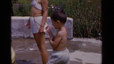 1951: kids and two mothers are playing at the water