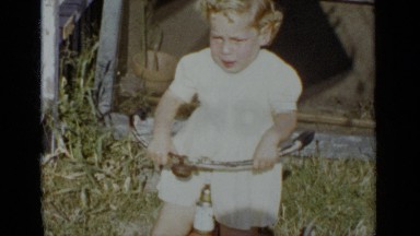 1951: the baby is trying to drive the bicycle on grassland NEW YORK